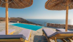 a pool with umbrellas and chairs and a swimming pool at Traditional villa in Sifnos