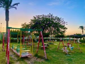 een speeltuin in een park met een palmboom bij قرية البوريڤاچ1 in Fayed