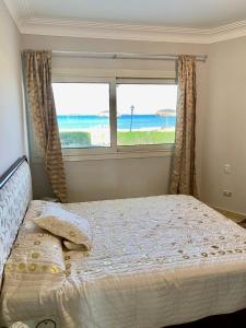 a bedroom with a bed with a view of the ocean at قرية البوريڤاچ1 in Fayed