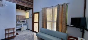 a living room with a blue couch and a television at Korp View House in Wang Nam Khieo