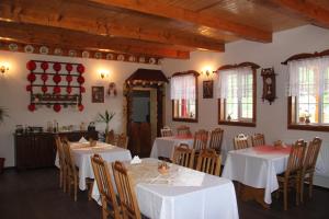 een eetkamer met witte tafels en stoelen bij Pensiunea Turlas Maria in Săliştea de Sus