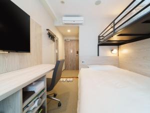 Cette chambre comprend un lit et une télévision. dans l'établissement Super Hotel Tokyo JR Kamata Nishiguchi, à Tokyo