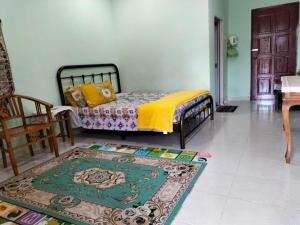 1 dormitorio con cama y alfombra en el suelo en Sofea Homestay, en Batu Rakit