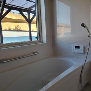 een badkamer met een bad en een raam bij Fluctus - Vacation STAY 16974v in Hitachi