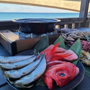 een bord vis op een tafel naast een grill bij Fluctus - Vacation STAY 16974v in Hitachi