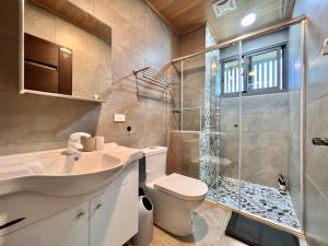 uma casa de banho com um chuveiro, um WC e um lavatório. em T-HOUSE em Taitung City