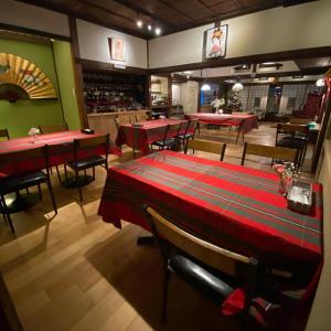 桐生市にあるOkiya Guest House & Tapas Barの赤いテーブルと椅子が備わるレストラン