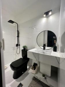 a bathroom with a sink and a toilet and a mirror at Habitacion en Carrasco, cerca del aeropuerto in Montevideo