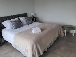 ein Bett mit zwei Handtüchern darauf in einem Schlafzimmer in der Unterkunft Arrayan in San Carlos de Bariloche