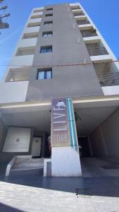 ein hohes Gebäude mit einem Schild davor in der Unterkunft TIERRA Alojamientos in Salta