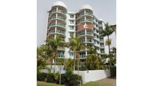 a tall building with palm trees in front of it at Mirage 602 in Tuncurry
