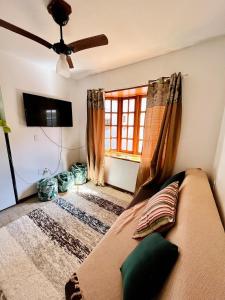 a living room with a couch and a window at Chales de Arraial d' Ajuda in Arraial d'Ajuda