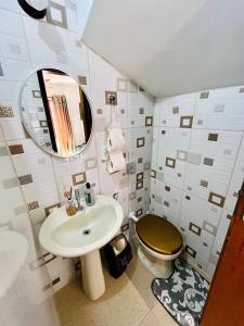a bathroom with a sink and a toilet and a mirror at Chales de Arraial d' Ajuda in Arraial d'Ajuda