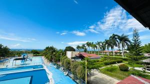 vista para uma piscina num resort com palmeiras em Tugsaw Resort em Sampong