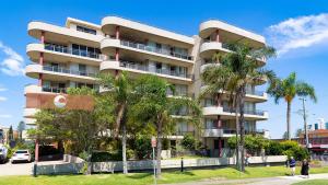 Un edificio alto con palmeras delante. en Sandbar Unit 203, en Forster