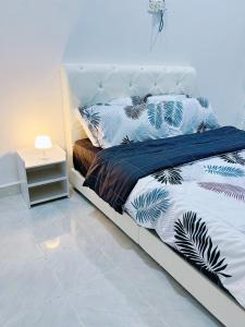 - une chambre avec un lit doté d'oreillers bleus et blancs dans l'établissement Iman Homestay Temerloh, à Temerloh
