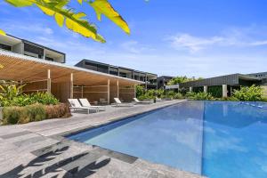 an image of a swimming pool in front of a house at Luxury with lake and hinterland views in Noosa Heads