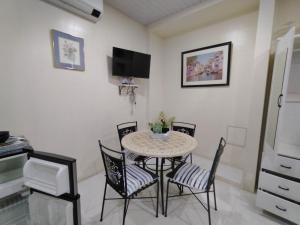 a dining room with a table and four chairs at Quirino Hub (401) in Davao City