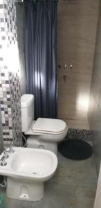 a bathroom with a white toilet and a sink at Sol y Montaña in San Juan