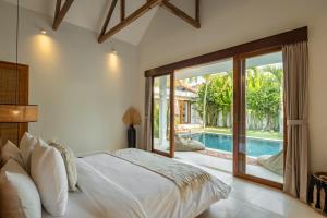 a bedroom with a bed and a swimming pool at Blue Door Villa, Central Canggu in Canggu +49 photos