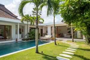 an image of a villa with a swimming pool and palm trees at Blue Door Villa, Central Canggu in Canggu