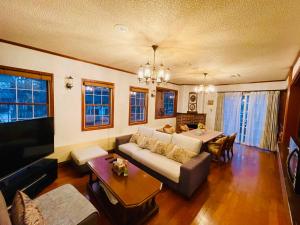una sala de estar con un sofá y una mesa en 極四季イン白馬 XSeasonsInnHAKUBA, en Hakuba