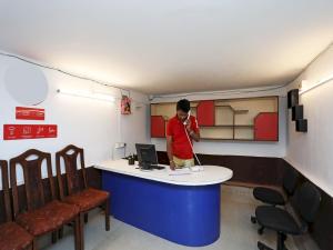 a man is standing at a counter in a room at Hotel O Jalan Lake View Near Mani Square in Tangra +43 photos
