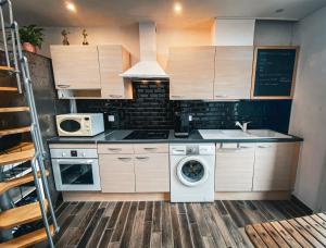 a kitchen with a washing machine and a microwave at Résidence Collioure Plage in Collioure