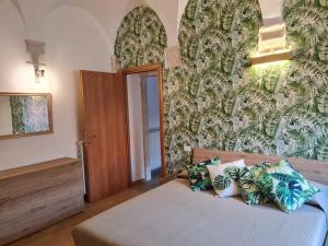 um quarto com uma cama e uma parede com plantas em Dimora degli angeli em LʼAquila