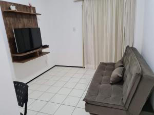 a living room with a couch and a flat screen tv at Flat Biarritz - próximo à praia in São Luís