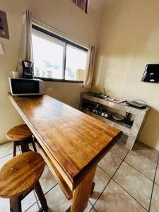 a kitchen with a wooden table and two stools at Ocean view in Monteverde Costa Rica