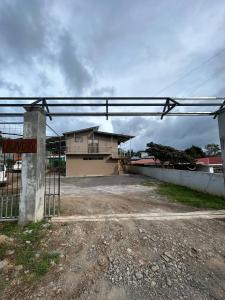 a gate in front of a house with a building at Ocean view in Monteverde Costa Rica