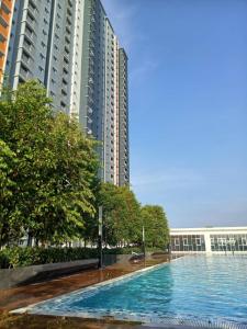 una piscina frente a algunos edificios altos en Adiniz KLIA Suite - Free Wi-Fi, en Sepang