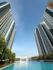 dos edificios altos con una piscina entre ellos en Adiniz KLIA Suite - Free Wi-Fi, en Sepang