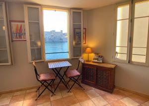 a room with two chairs and a desk and a window at Résidence Collioure Plage in Collioure