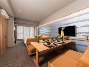 ein Hotelzimmer mit einem Esstisch und einem Wohnzimmer in der Unterkunft MIMARU KYOTO KAWARAMACHI GOJO in Kyoto
