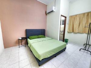 Schlafzimmer mit einem Bett mit blauem Kopfteil in der Unterkunft Taiping Homestay Near Lakegarden in Taiping