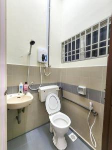 ein Bad mit einem WC und einem Waschbecken in der Unterkunft Taiping Homestay Near Lakegarden in Taiping