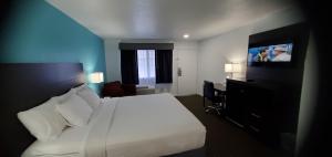 a hotel room with a bed and a flat screen tv at Travelodge by Wyndham Livonia Canton Novi Detroit Area in Livonia
