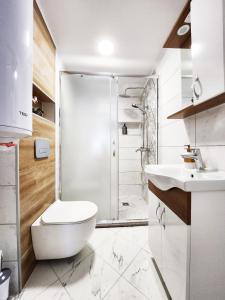 een badkamer met een douche, een toilet en een wastafel bij Apartment Varna in Varna