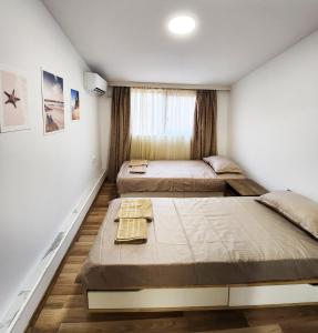 een slaapkamer met 2 bedden en een raam bij Apartment Varna in Varna