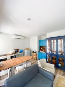 a kitchen with blue cabinets and a wooden table at fio's house by the sea in Cha Am