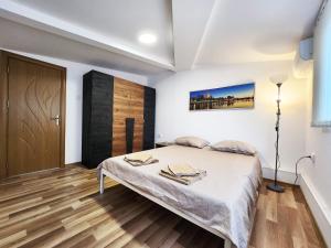 een slaapkamer met een bed en een houten vloer bij Apartment Varna in Varna