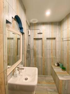 a bathroom with a sink and a mirror and a shower at fio's house by the sea in Cha Am
