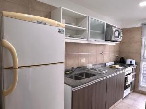 eine Küche mit einem weißen Kühlschrank und einer Spüle in der Unterkunft Modern&Nordic Apartament Lomitas (2 ambientes) in Partido Lomas de Zamora