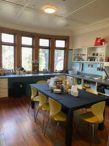 uma cozinha com uma mesa com cadeiras amarelas em Manor house backpackers em Dunedin