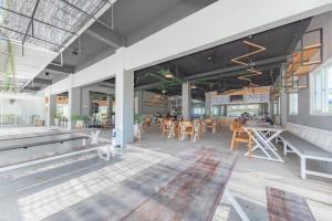 a restaurant with tables and chairs in a building at Urbanview Hotel The Tang Balikpapan by RedDoorz in Balikpapan