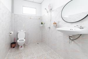uma casa de banho com um WC, um lavatório e um espelho. em Garden Home 2 em Haad Yao