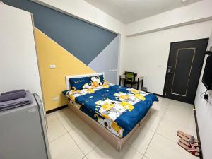 a bedroom with a bed with a blue comforter at 週週客棧 in Yongkang