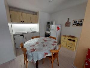 a kitchen with a table and chairs and a refrigerator at Appartement cosy à Autrans, 6 pers, 54m², balcon, proche pistes et commerces - FR-1-737-49 in Autrans +6 photos